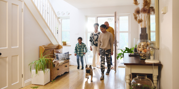 family walking into their home with their dog